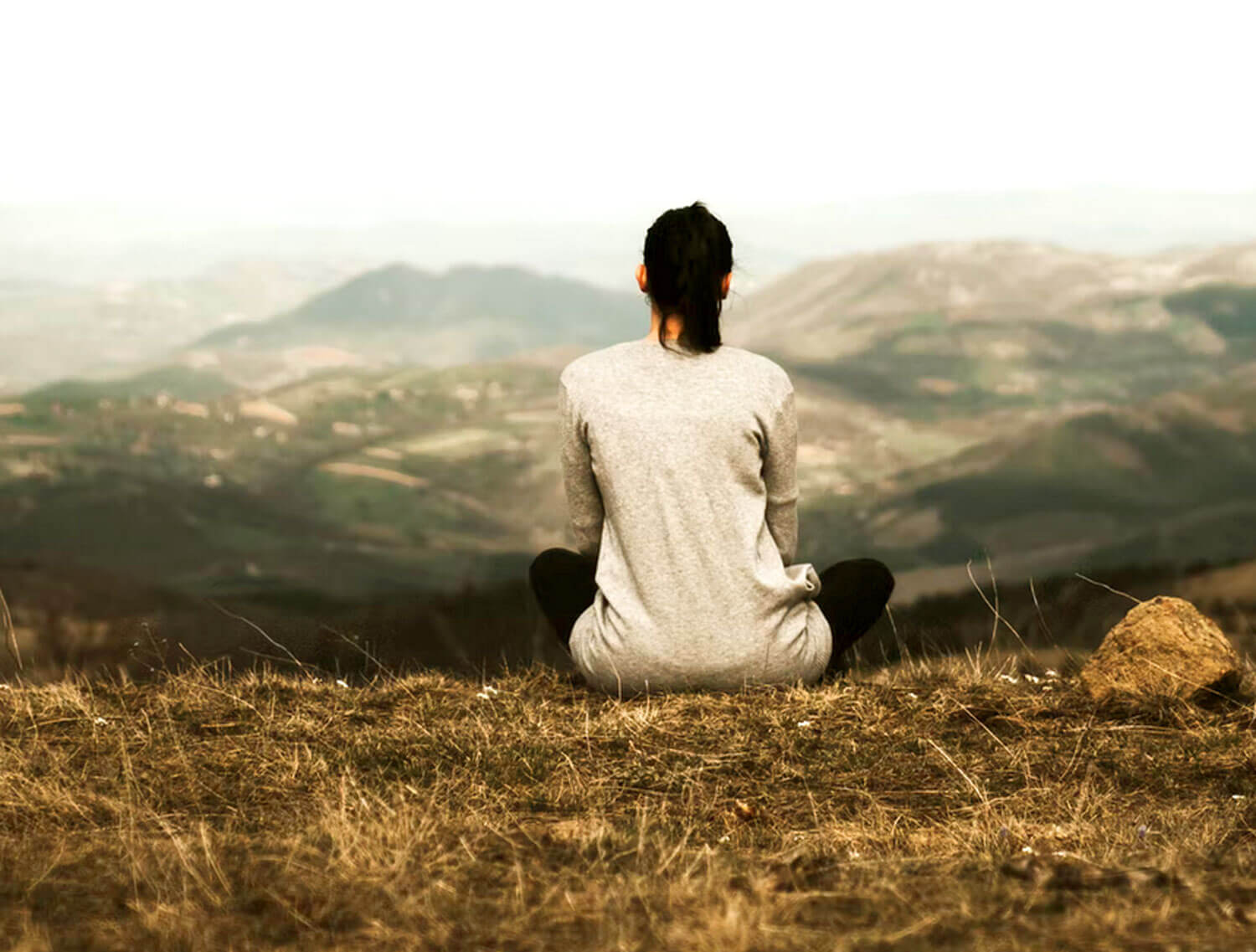 Photo of woman sitting on grass.
