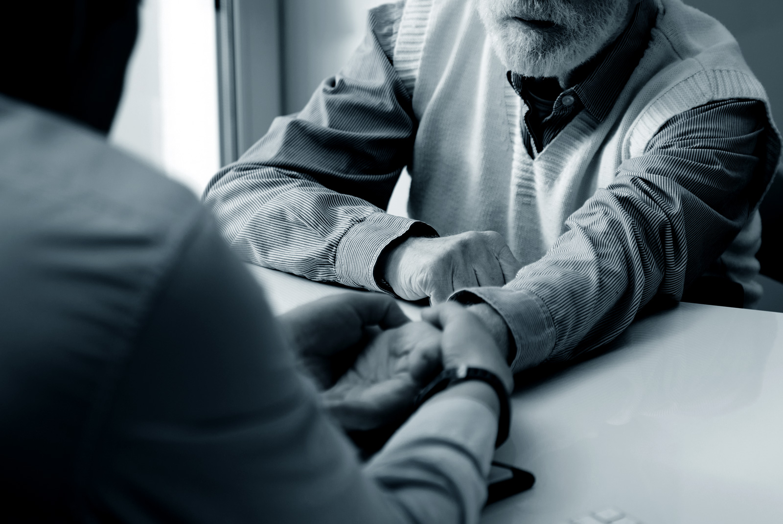 Photo of someone's hand being examined by doctor. 
