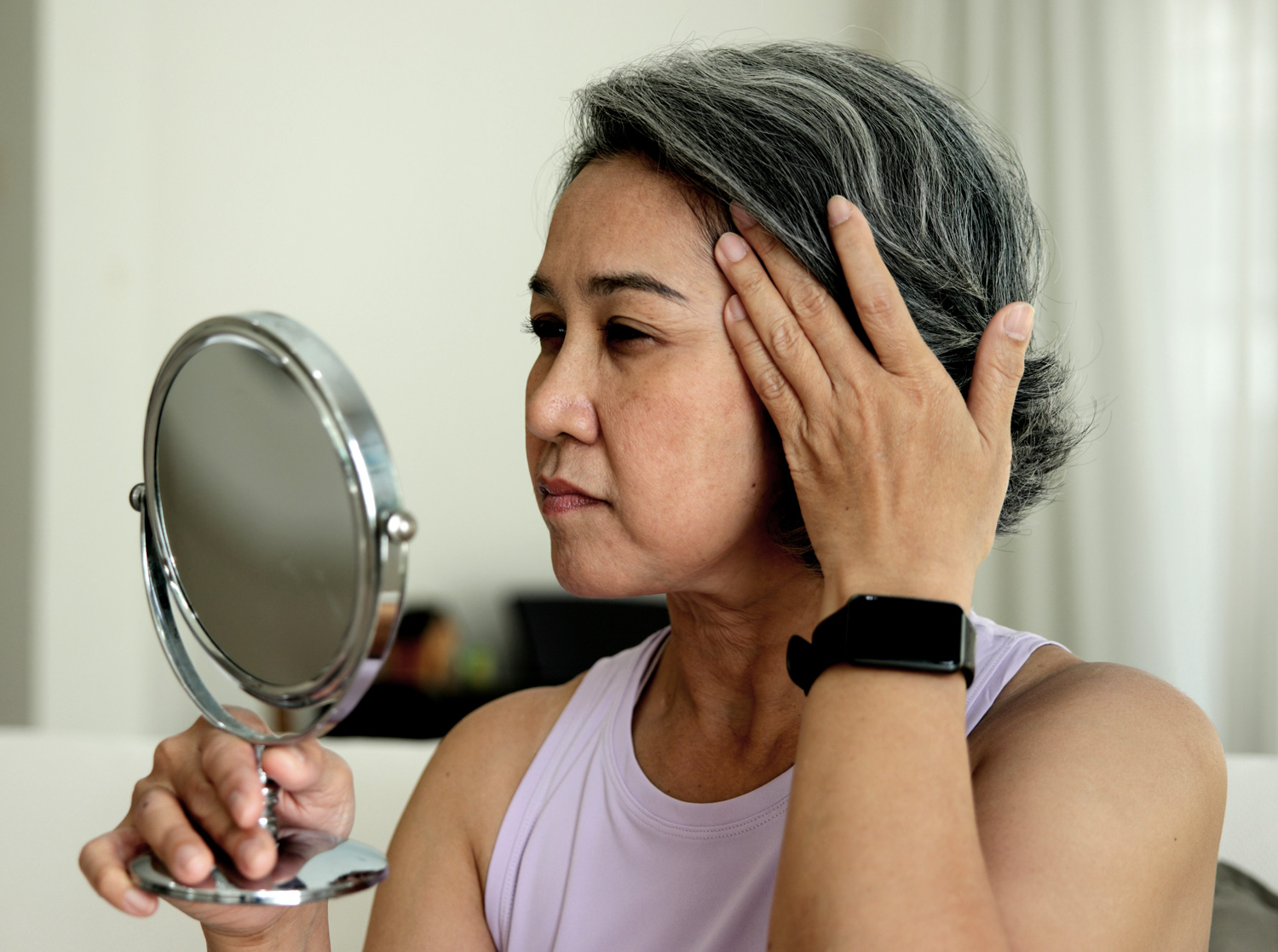 Photo of woman looking into mirror.